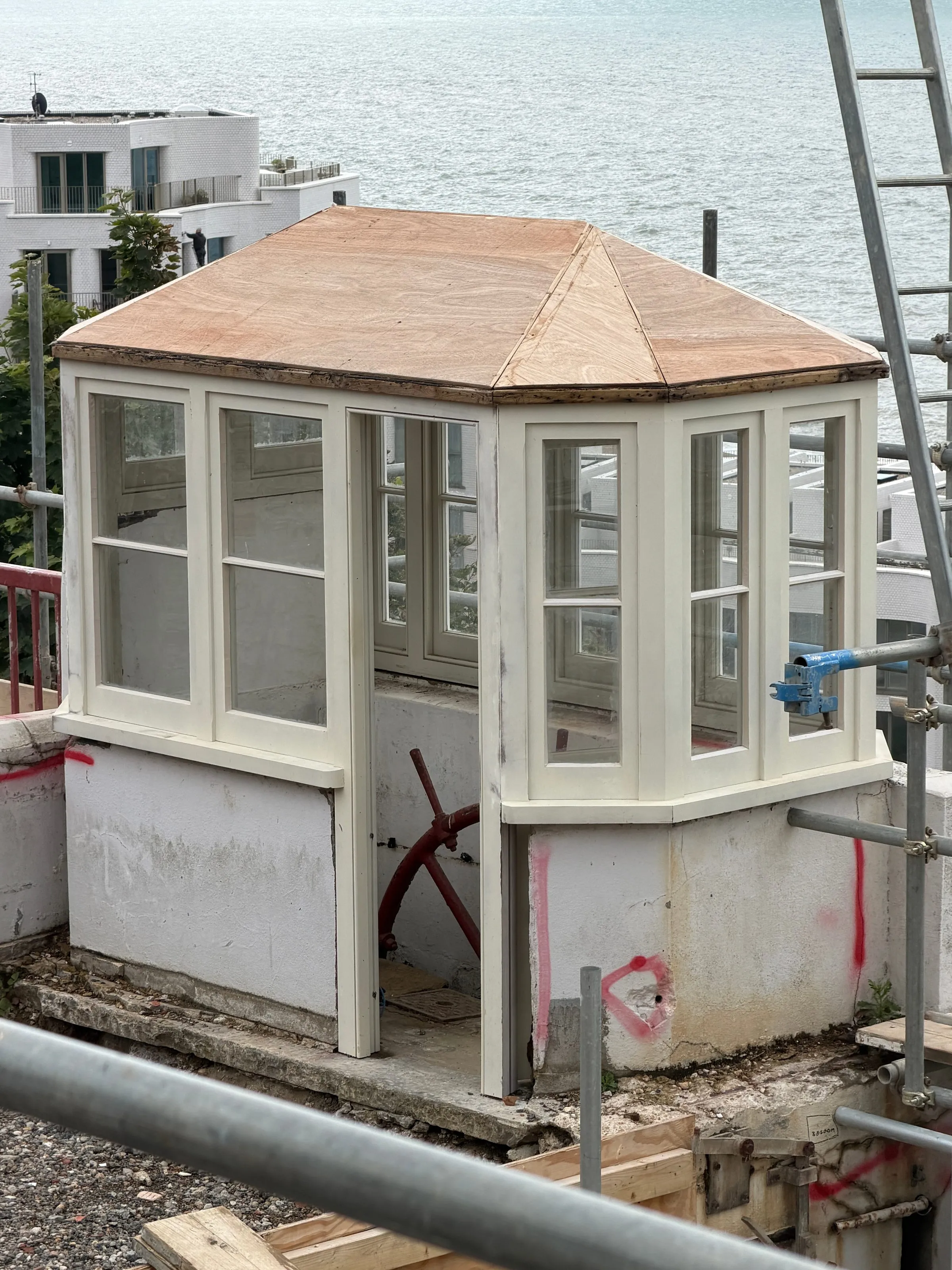 Restored white timber wheelhouse kiosk at the top of the Leas Lift, overlooking the sea