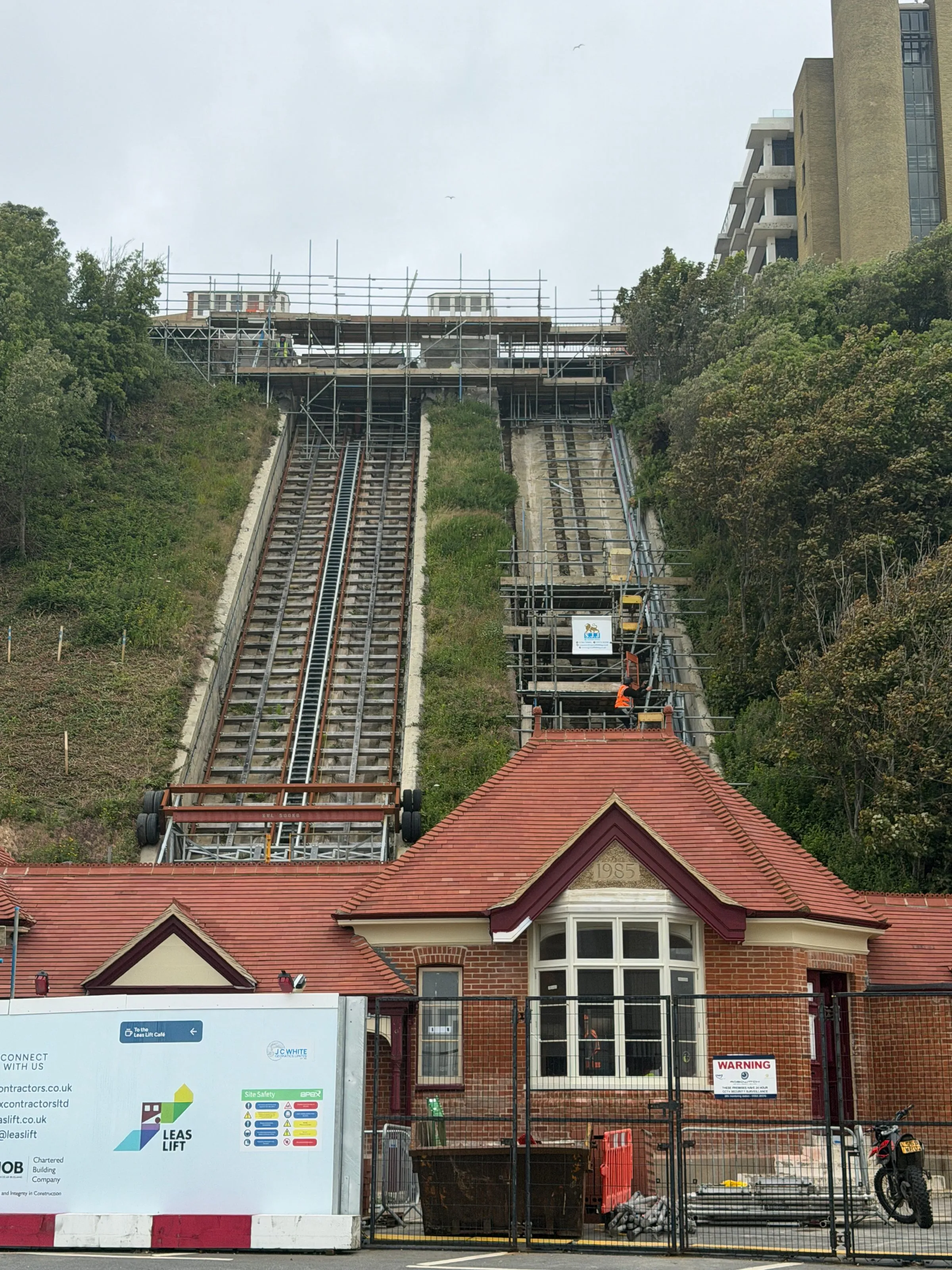 Leas Lift funicular tracks rising up the cliff behind the red-brick 1885 ticket office, Folkestone, during restoration