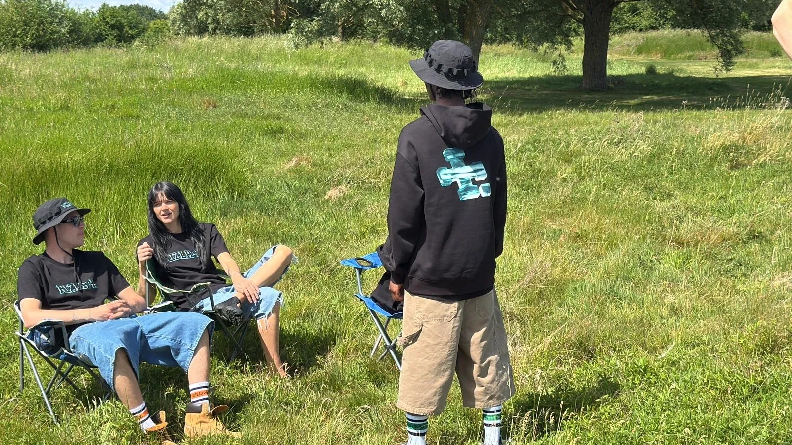Mattia Guarnera-MacCarthy and Rizla shoot on location in a field, cast in branded T-shirts, hoodie and camping chairs