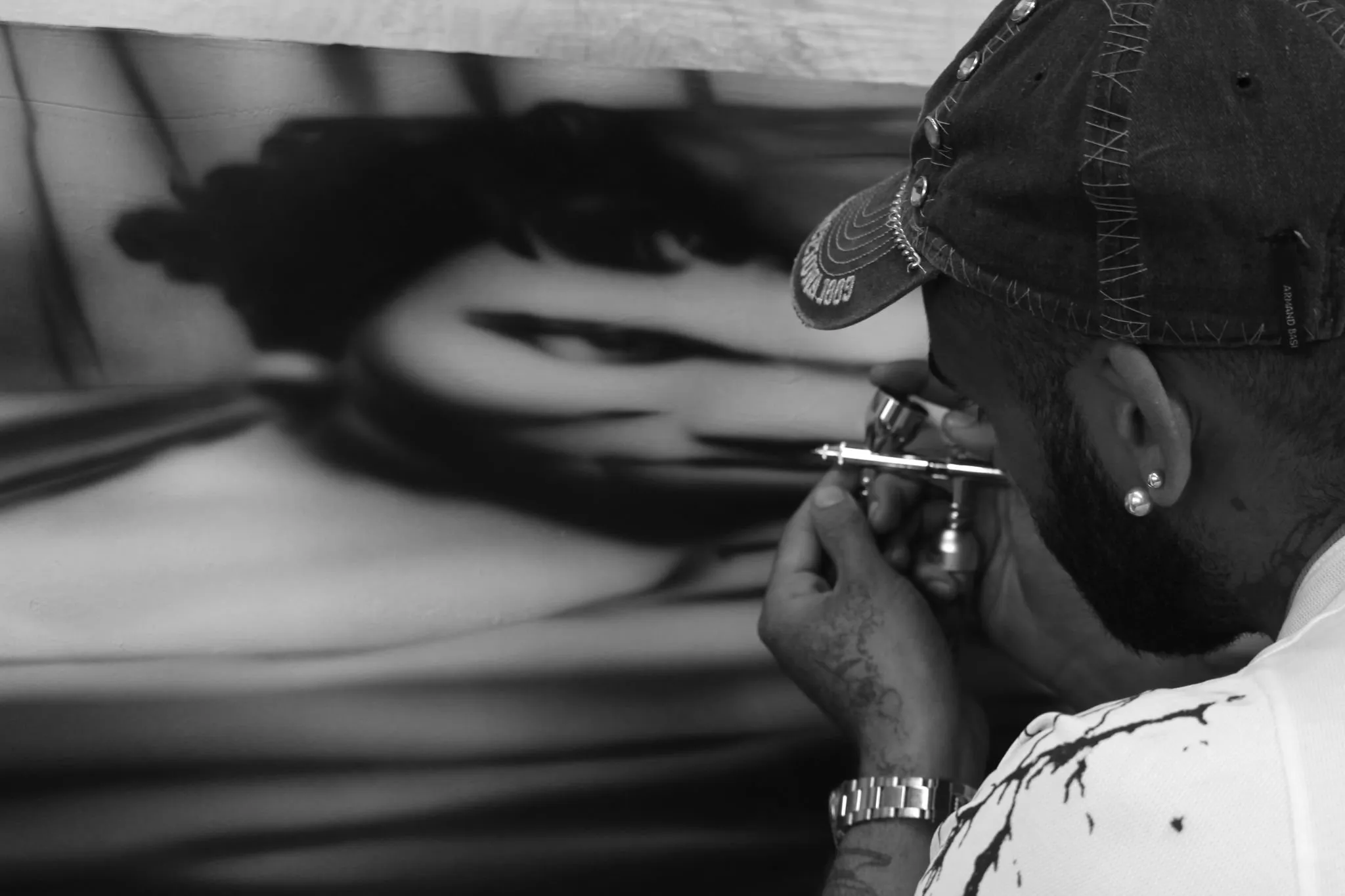 Close-up of Mattia Guarnera-MacCarthy’s hand on the airbrush as he works on the reclining-figure painting